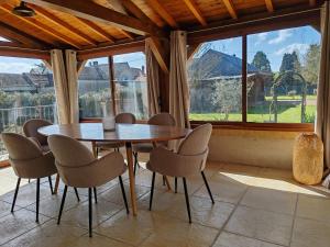 a table and chairs in a room with a large window at La Gigotière, 5mn du ZooParc de Beauval in Noyers-sur-Cher