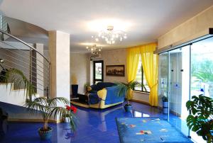uma sala de estar com um sofá azul e algumas plantas em Hotel Del Sole em Pastorano