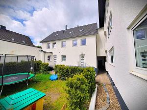 a backyard with a trampoline in front of a house at Stadt Apartments Solingen in Solingen
