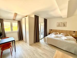 a bedroom with a bed and a table and a desk at Cloud9 Apartments & Rooms in Močići