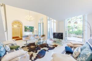 un soggiorno con un divano e una TV di LA PERLE Luxueux Apt 135m2 Piscine Tennis Plage Privée a Roquebrune-Cap-Martin
