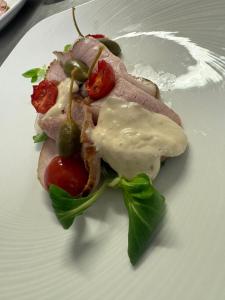 a sandwich with meat and vegetables on a white plate at Hotel New Arpa in Rimini +21 photos
