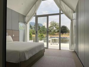 a bedroom with a bed and a large window at M & R 2 float house in Muang Fuang