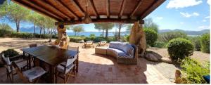 a patio with a table and chairs under a wooden roof at Villa Gaviel, villa con accesso diretto al mare in Porto Istana