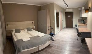 a bedroom with a large bed and a kitchen at Apartament e310 - Bel Mare Międzyzdroje in Międzyzdroje