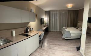 a kitchen and living room with a bed in the background at Apartament e310 - Bel Mare Międzyzdroje in Międzyzdroje