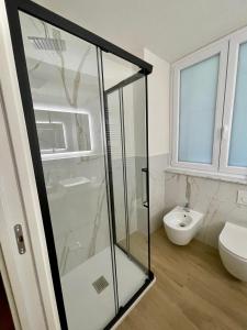 a bathroom with a glass shower and a toilet at Deluxe Apartment a 2 passi dal mare - FIERA GENOVA in Genova