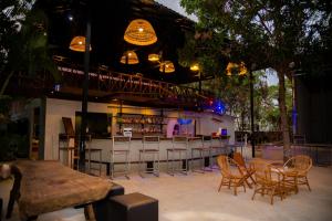 a bar with chairs and a table and a counter at River Nest Hostel in Kampot