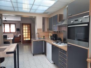 a kitchen with a sink and a stove top oven at Maison Chez Lili à 200 m de la plage ,jardin privé et clos in Gravelines