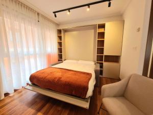 a bedroom with a bed and a chair and a mirror at Apartamento Seymi in Durango +3 photos