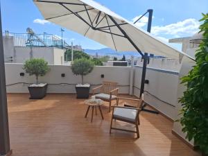 a patio with a white umbrella on a roof at Luxury transformable loft in Athens