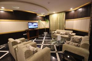 sala de estar con sofás y TV de pantalla plana. en Tooq Suites, en Riad