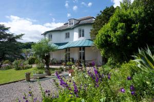 una gran casa blanca con flores en el patio en Woodlands, Teignmouth, en Teignmouth 34 fotos más