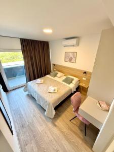 a hotel room with a bed and a desk at Cloud9 Airport Rooms in Močići +6 photos