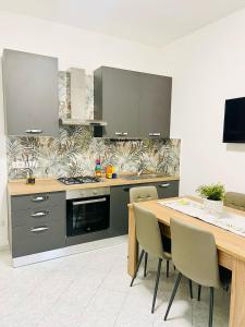 a kitchen with a table and a stove and cabinets at GioGio house in Vico Equense