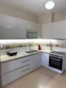 a kitchen with white cabinets and a sink at Velipoja Apartment in Velipojë