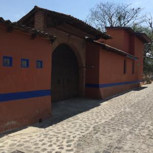 ein orangefarbenes und blaues Gebäude mit einer Tür in der Unterkunft Finca Las Palmas in Malinalco