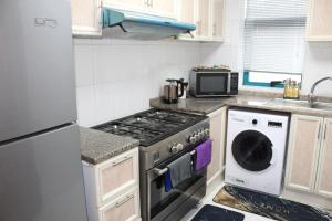 a kitchen with a stove and a washing machine at Ajman for families in Ajman 