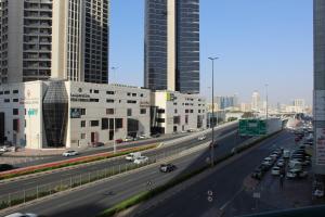 a highway in a city with tall buildings and cars at Ajman for families in Ajman 