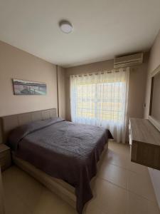 a bedroom with a large bed and a window at Velipoja Apartment in Velipojë