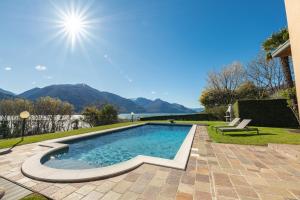 a swimming pool in a backyard with mountains in the background at Villa Principessa - Private Villa with Panoramic Lake Como Views in Cremia