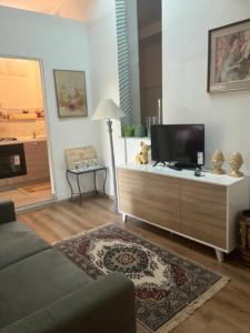 a living room with a couch and a tv at La dimora Poliziana di Anna in Montepulciano