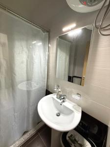 a bathroom with a sink and a shower with a mirror at Velipoja Apartment in Velipojë +18 photos