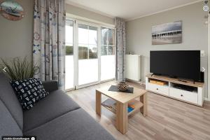 a living room with a couch and a flat screen tv at Ostseemuschel Laboe in Laboe