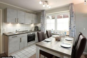 a kitchen with a table with chairs and a dining room at Ostseemuschel Laboe in Laboe