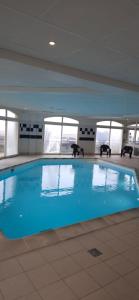 a large blue swimming pool in a building at SUNSET 3o2 in Cayeux-sur-Mer