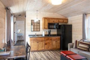 a kitchen and living room in a log cabin at CHICKADEE LIMIT 4 in North Sebago +6 photos