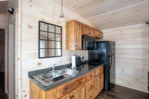 a kitchen with a sink and a black refrigerator at CARDINAL LIMIT 3 in North Sebago +6 photos