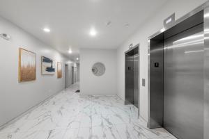 a hallway with white walls and a silver elevator at Luxury 1br Nolibs Pool Access in Philadelphia