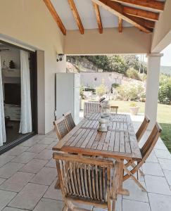 un tavolo e sedie di legno su un patio di Villa pour 8 avec piscine a Compoli