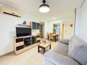 a living room with a couch and a flat screen tv at ACV - Torremar-2ª linea planta 3 sur 2 in El Borseral