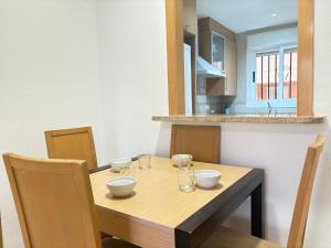 a wooden table with bowls and glasses on it in a kitchen at ACV - Torremar-2ª linea planta 3 sur 2 in El Borseral