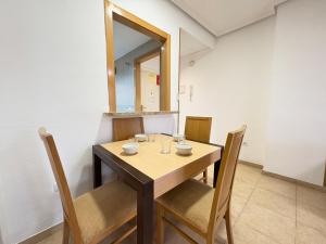 a dining room table with chairs and a mirror at ACV - Torremar-2ª linea planta 3 sur 2 in El Borseral +9 photos