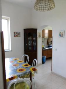 a dining room with a table and a kitchen at Villa Mirabelli in Tropea