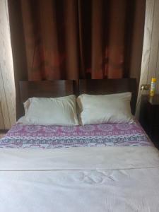 un letto con 2 cuscini e una coperta viola di Backpack Cabin A12892 a Oranjestad