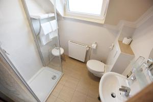 a bathroom with a shower and a toilet and a sink at Gästehaus Spatzennest in Maikammer +2 photos