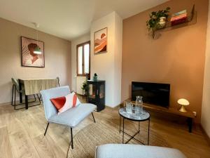 a living room with a tv and a chair and a table at Le Charme du Perigord - chambre & table d'hotes in Saint-Sulpice-dʼExcideuil