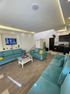 Al RamaFiruza Farm Villa Vip的客厅里有两张蓝色沙发和一张桌子。 更多19张照片