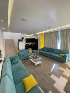 Al RamaFiruza Farm Villa Vip的客厅里有两张蓝色沙发和一张桌子。