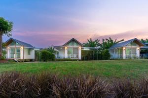 a row of cottages on the beach at sunset at Narucha Farmstay in Ban Chuk Yai Yuan