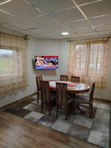 una sala da pranzo con tavolo, sedie e TV di Vikendica Matić a Goč