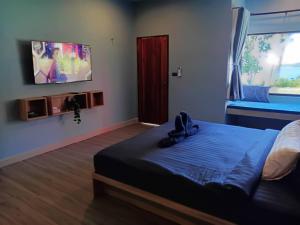 a bedroom with a bed and a tv on the wall at ลานแลเล รีสอร์ท ชุมพร Larn-Lae-Lay Resort Chumphon in Ban Fang Daeng (1)