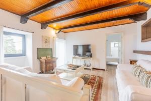 a living room with white furniture and a flat screen tv at Solar do Maranhão in Capelas
