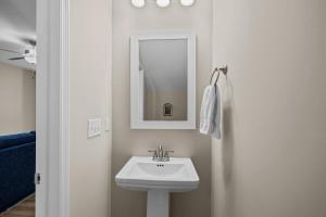 a white bathroom with a sink and a mirror at Chadwick Cottage townhouse in Beaufort +48 photos