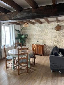 a living room with a table and chairs at Les granges in Bernay