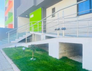 a building with stairs and a palm tree in the grass at Noa Residence in Alba Iulia